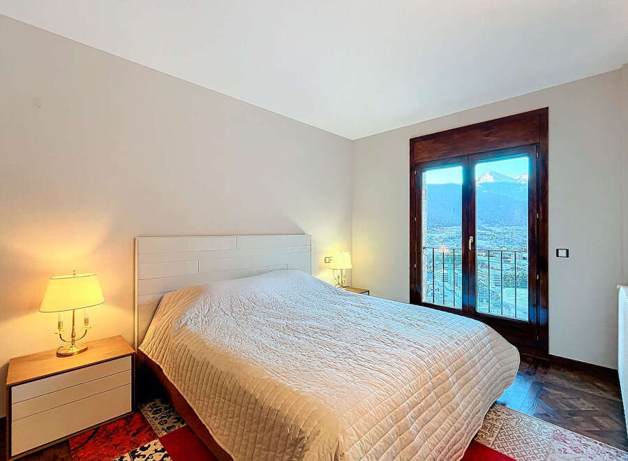 Experience the tranquility of this beautifully designed bedroom, featuring a cozy bed and a stunning view.