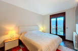Experience the tranquility of this beautifully designed bedroom, featuring a cozy bed and a stunning view.