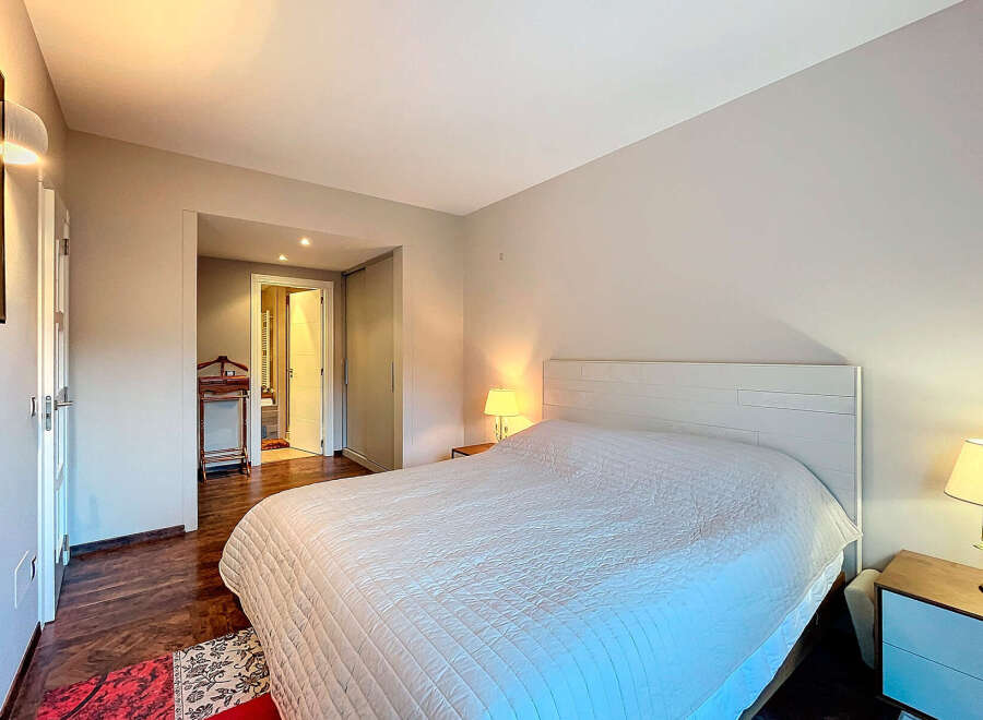 Discover the tranquility of this inviting bedroom, featuring a comfortable bed and a serene ambiance.
