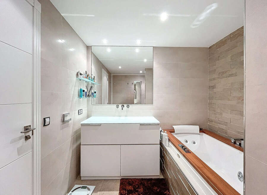 This modern bathroom features a sleek design with a luxurious soaking tub and a stylish vanity.