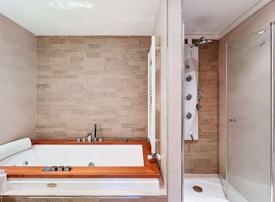 Indulge in luxury with this stunning bathroom featuring a sleek jacuzzi and a separate shower.