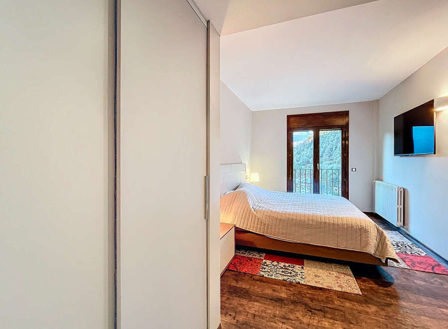 Discover the tranquility of this inviting bedroom, featuring a cozy bed and a stunning view.