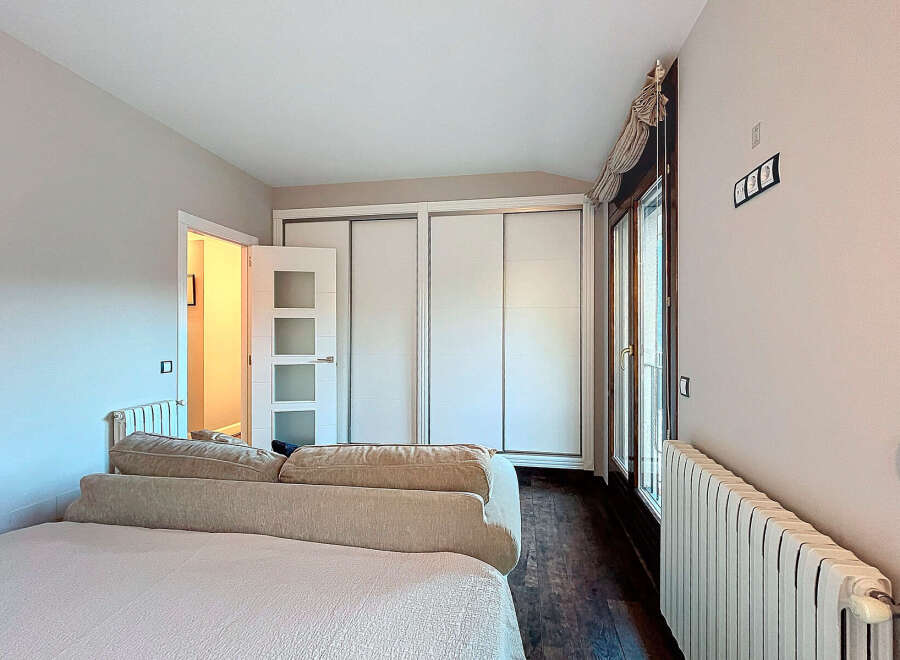 Discover this inviting bedroom featuring a comfortable bed and a stylish sofa.
