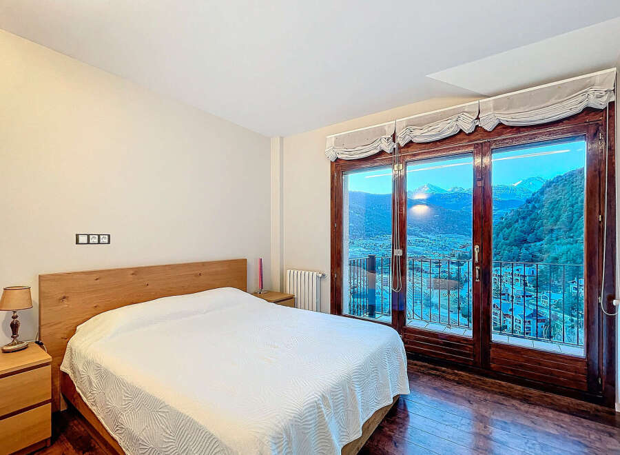 Experience breathtaking mountain views from this stunning bedroom.
