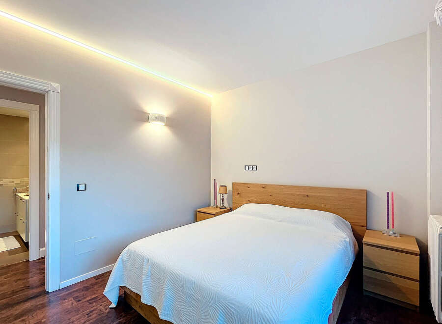 This stunning bedroom boasts a modern design with a warm and inviting ambiance.