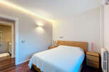 This stunning bedroom boasts a modern design with a warm and inviting ambiance.