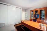 Discover the elegance of this well-appointed home office, featuring a classic wooden desk and a built-in bookcase.