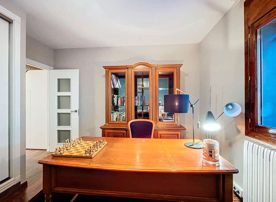This elegant home office features a classic wooden desk and a built-in bookcase, perfect for a productive workspace.