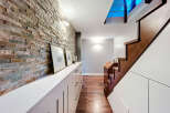 This stunning property features a beautifully designed hallway with a striking brick wall, creating a warm and inviting atmosphere.