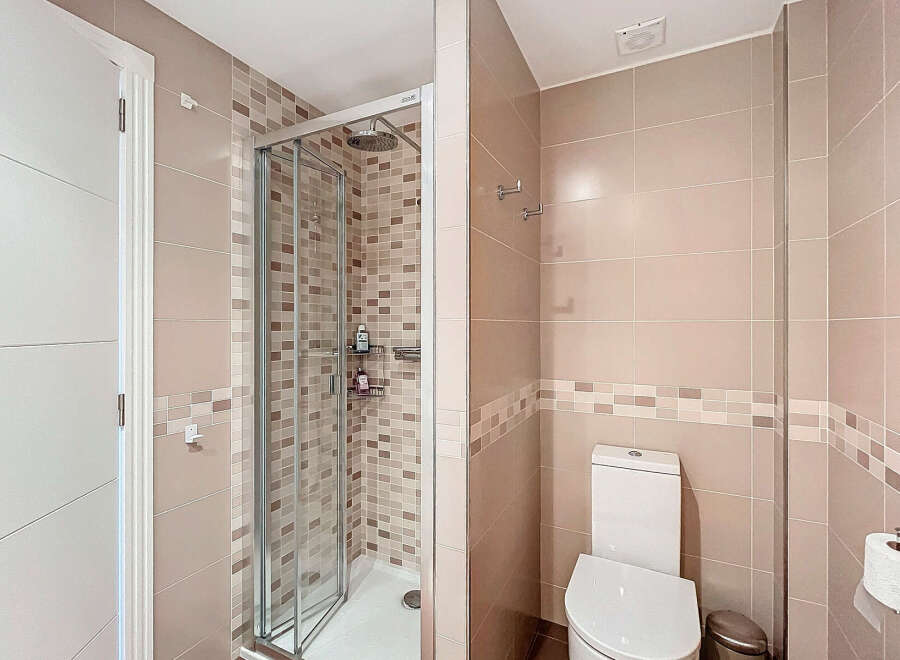 Step into this modern bathroom featuring a sleek glass shower enclosure and stylish tile work.