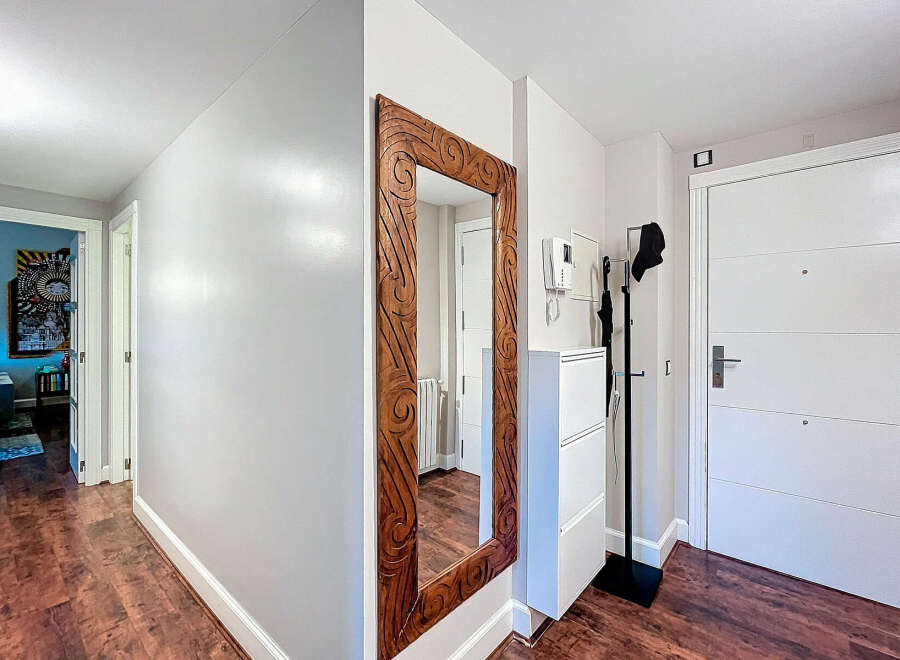 Step into this inviting entryway, featuring a striking wooden-framed mirror that adds a touch of elegance.