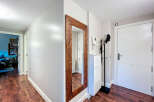 Step into this inviting entryway, featuring a striking wooden-framed mirror that adds a touch of elegance.