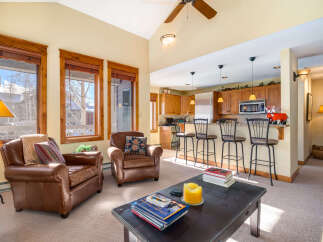 This stunning property boasts a cozy living area with two comfortable leather armchairs, perfect for relaxing after a long day.