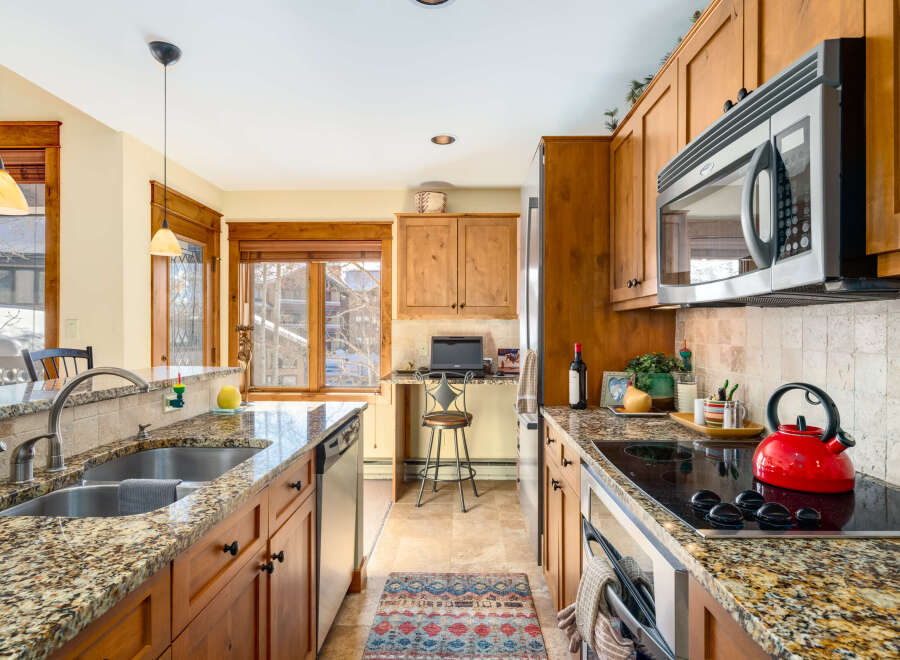 This stunning kitchen boasts beautiful granite countertops and warm wooden cabinetry, creating an inviting atmosphere.