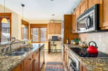 This stunning kitchen boasts beautiful granite countertops and warm wooden cabinetry, creating an inviting atmosphere.