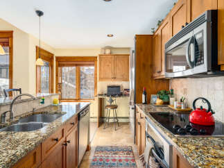 This stunning kitchen boasts beautiful granite countertops and warm wooden cabinetry, creating an inviting atmosphere.