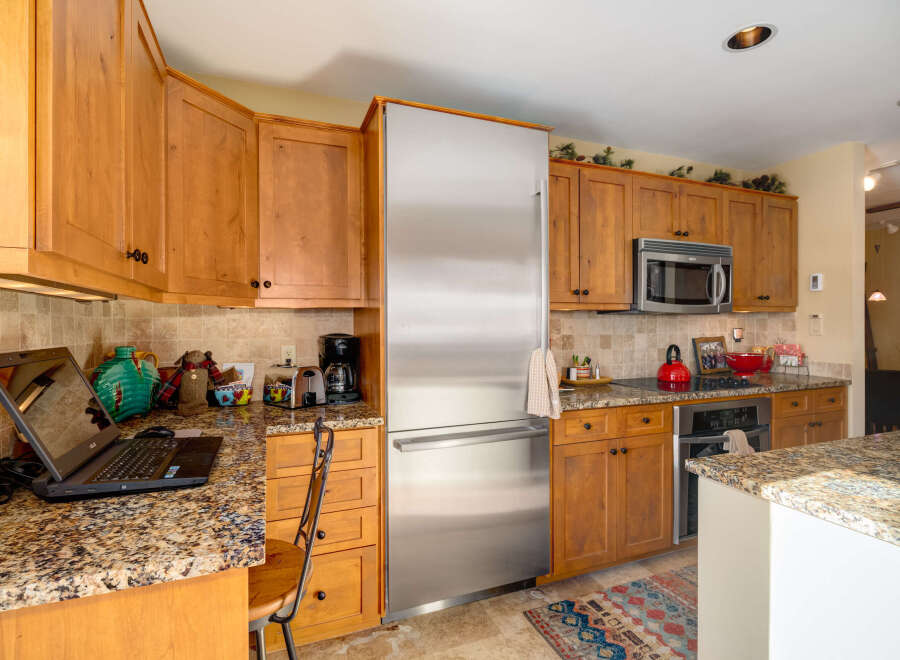 This stunning kitchen boasts beautiful wooden cabinetry and granite countertops, creating a warm and inviting atmosphere.