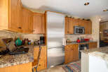 This stunning kitchen boasts beautiful wooden cabinetry and granite countertops, creating a warm and inviting atmosphere.