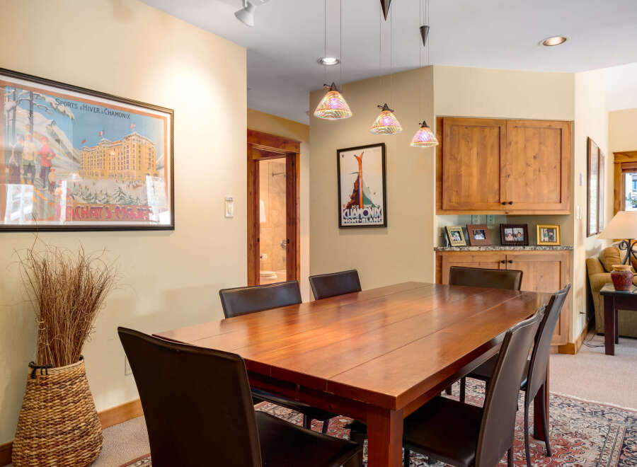 This stunning dining area features a beautiful wooden table, perfect for hosting gatherings.