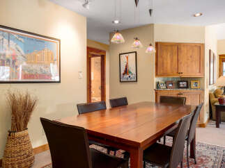 This stunning dining area features a beautiful wooden table, perfect for hosting gatherings.