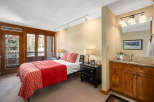 This stunning bedroom boasts a cozy ambiance with its inviting red bedding and stylish decor.