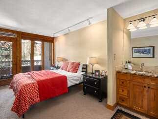 This stunning bedroom boasts a cozy ambiance with its inviting red bedding and stylish decor.