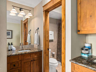 Step into this beautifully designed bathroom, featuring a warm wooden vanity and a stunning granite countertop.
