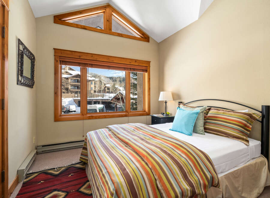 This cozy bedroom offers a serene retreat with a stunning view.