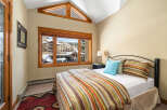 This cozy bedroom offers a serene retreat with a stunning view.