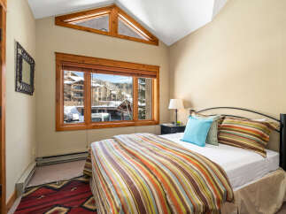 This cozy bedroom offers a serene retreat with a stunning view.