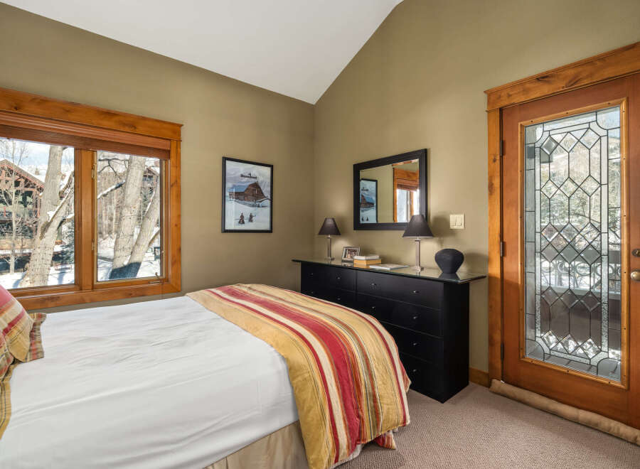 This cozy bedroom features a comfortable bed with a colorful striped comforter, perfect for a relaxing retreat.