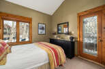 This cozy bedroom features a comfortable bed with a colorful striped comforter, perfect for a relaxing retreat.