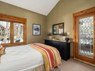 This cozy bedroom features a comfortable bed with a colorful striped comforter, perfect for a relaxing retreat.