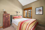 This cozy bedroom features a comfortable bed with a colorful striped comforter and pillows, creating a warm and inviting atmosphere.
