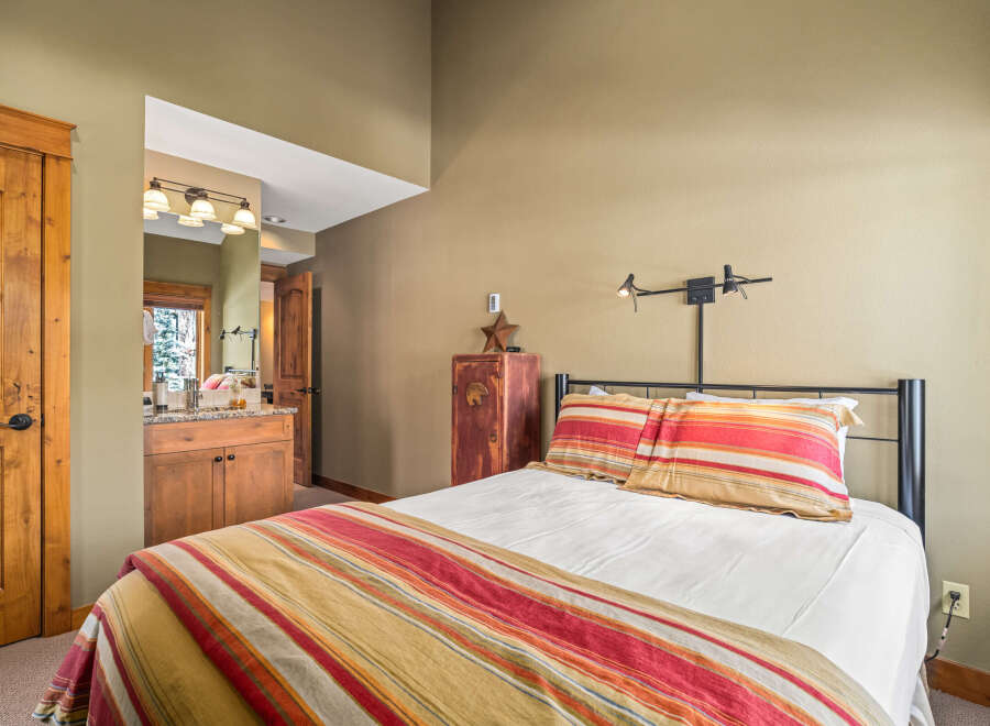 Discover the charm of this cozy bedroom, featuring a comfortable bed with colorful bedding and pillows.
