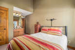 Discover the charm of this cozy bedroom, featuring a comfortable bed with colorful bedding and pillows.