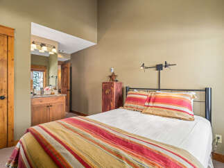 Discover the charm of this cozy bedroom, featuring a comfortable bed with colorful bedding and pillows.
