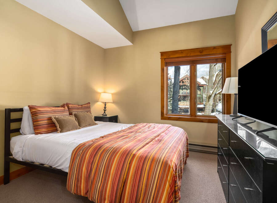 This cozy bedroom offers a serene retreat with its warm color palette and inviting ambiance.