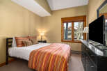 This cozy bedroom offers a serene retreat with its warm color palette and inviting ambiance.