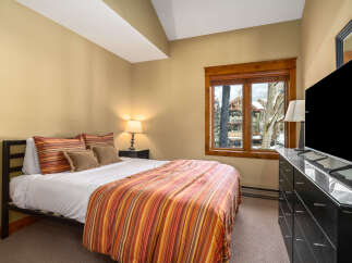 This cozy bedroom offers a serene retreat with its warm color palette and inviting ambiance.