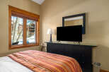 This cozy bedroom features a comfortable bed with a vibrant striped comforter, perfect for a relaxing stay.