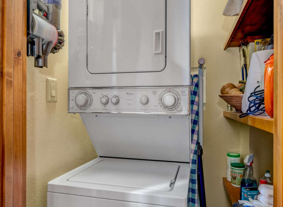 Discover the convenience of this well-equipped laundry area, featuring a modern stacked washer and dryer.