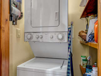 Discover the convenience of this well-equipped laundry area, featuring a modern stacked washer and dryer.