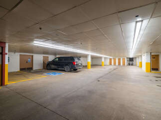 This spacious parking garage offers ample space for vehicles and features designated handicap parking.