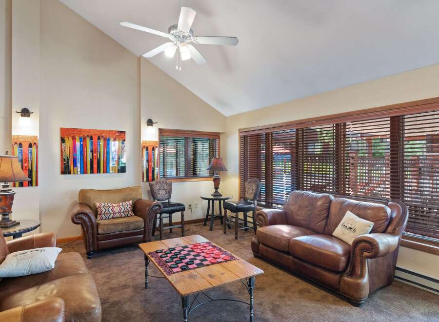 This cozy living room features a comfortable leather sofa and armchair, perfect for relaxing.