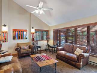 This cozy living room features a comfortable leather sofa and armchair, perfect for relaxing.