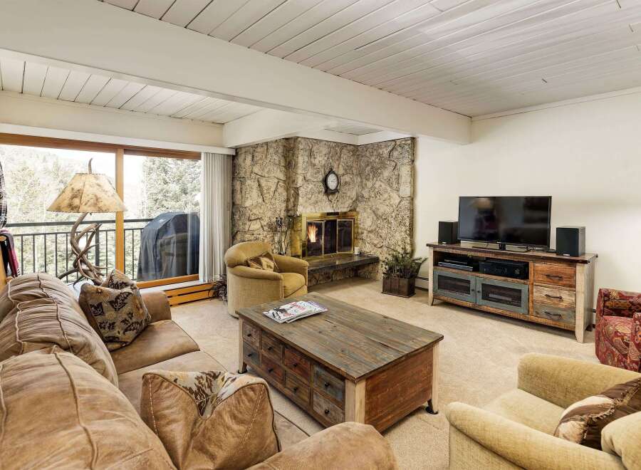 Step into a cozy living space featuring a stunning stone fireplace, perfect for those chilly evenings.