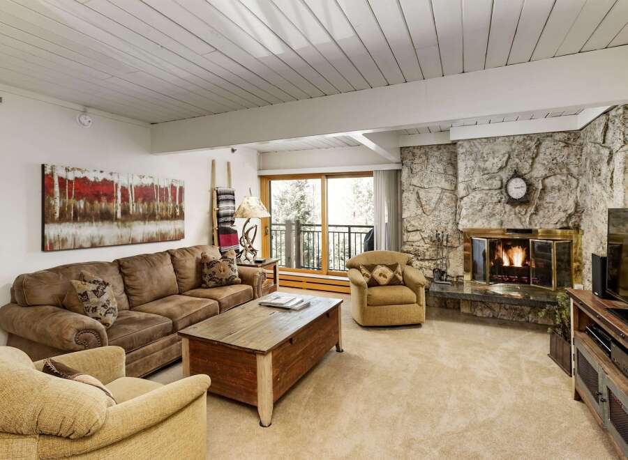 This cozy living room features a stunning stone fireplace, perfect for those chilly evenings.