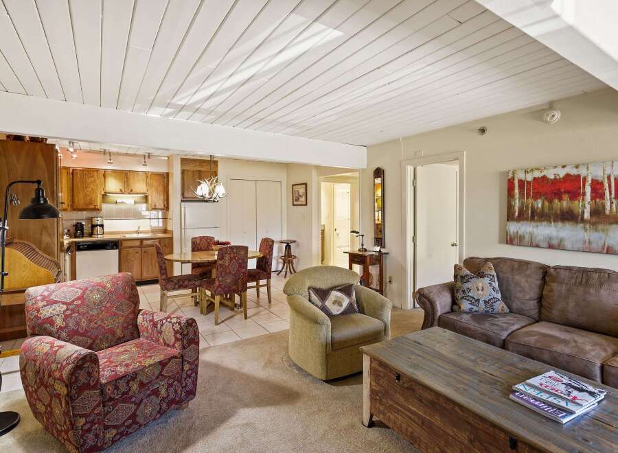 This charming property boasts a cozy living space with a stylish sofa and a unique coffee table, perfect for relaxation.