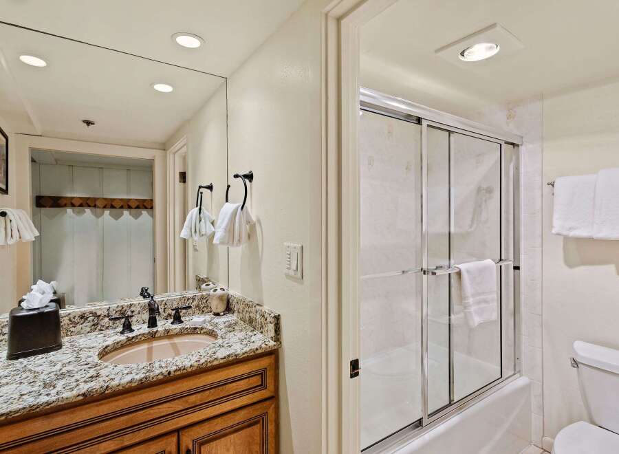This stunning bathroom features a beautiful granite countertop and a stylish sink.